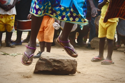 Women play an important role in the Rule, attending the ceremony and providing additional means of entertainment, such as this game, Women take turns jumping on and off the rock to the beat of the drums, leaving the center of the circle when they err.